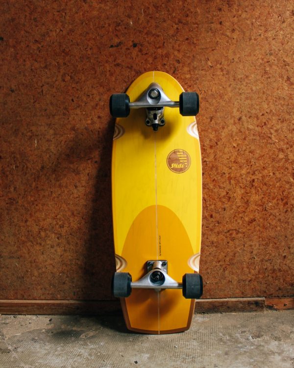 Slide Surfskate Quad Sunset Onderkant met board tegen de muur